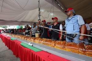 Officials weigh the world's largest Pan de Jamón in Caracas, Venezuela, Saturday, Nov. 15. Hundreds of cooks and spectators were on hand for the creation of the Pan de Jamón, a Christmas specialty in which ham is rolled in sweet bread, as well as the world's biggest hallaca, a local take on the tamale traditionally eaten in December. (AP photo)